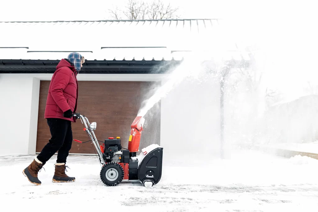 A man working for Ponderosa Pathways is clearing snow in Flagstaff.
