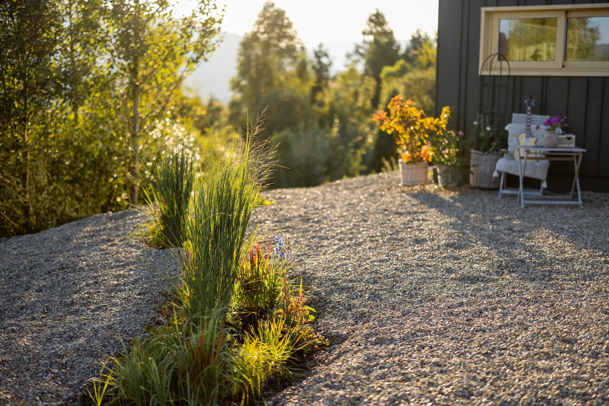 Completed xeriscaping project in Flagstaff with gravel walkways, native plants, and bark mulch arranged around a modern front yard.